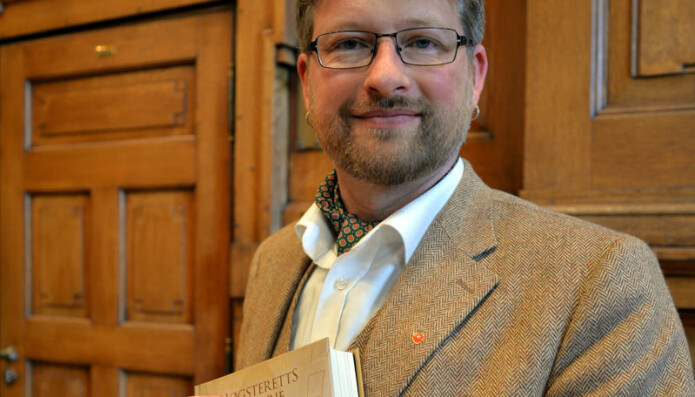 Jørn Øyrehagen Sunde, her med hans bok om Høyesteretts historie.