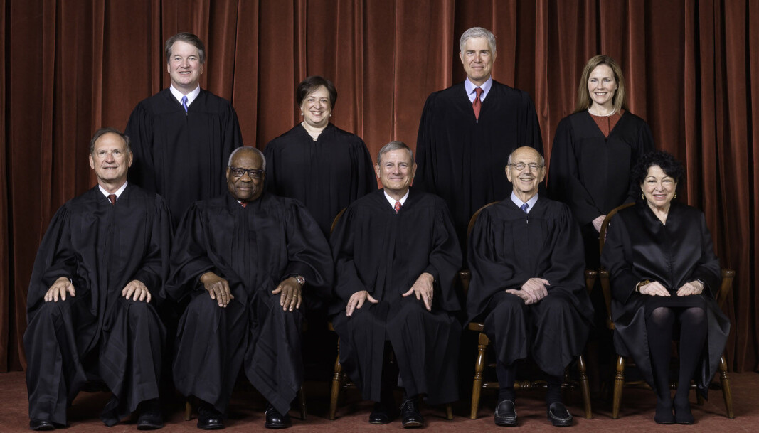 Første rad fra v. Samuel A. Alito, Jr., Clarence Thomas, justitiarius John G. Roberts, Jr., Stephen G. Breyer og Sonia Sotomayor. Bakre rad fra v. Brett M. Kavanaugh, Elena Kagan, Neil M. Gorsuch og Amy Coney Barrett. Første rad fra v. Samuel A. Alito, Jr., Clarence Thomas, justitiarius John G. Roberts, Jr., Stephen G. Breyer og Sonia Sotomayor. Bakre rad fra v. Brett M. Kavanaugh, Elena Kagan, Neil M. Gorsuch og Amy Coney Barrett.